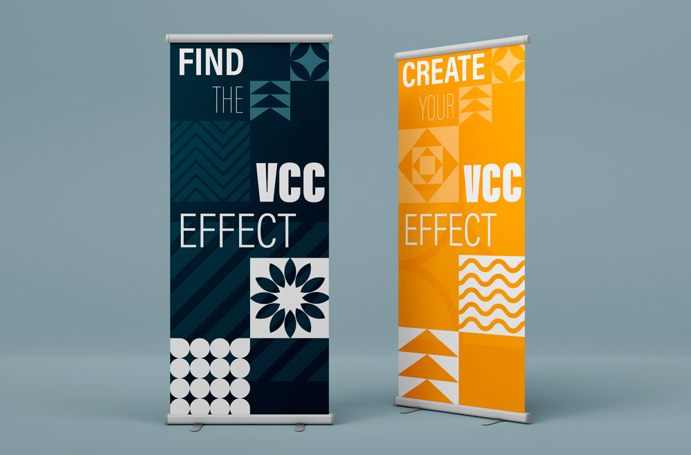 Two roll-up banners for Vancouver Community College, one blue, one yellow, displaying brand colours and patters, and say Find the VCC effect, and Discover the VCC effect respectively.